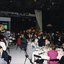People seated around tables in Studio 1 at Channel 9 with a large television showing a male singer