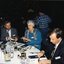 Two men and one woman seated at a table preparing for the lunch