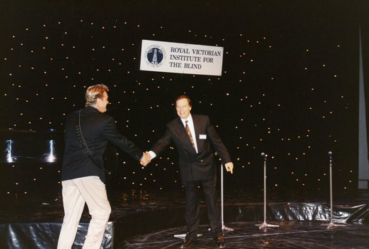 Pete Smith puts out his hand to shake that of Peter Cupples as he comes on stage
