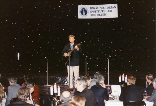 Peter Cupples singing to the audience and playing guitar