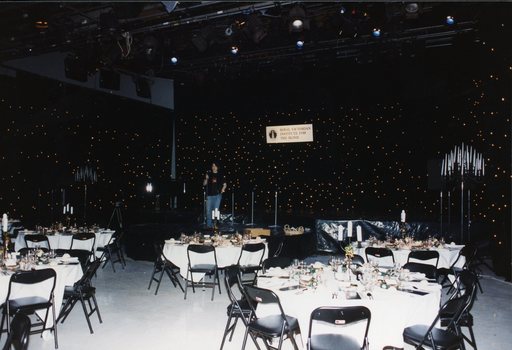 Behind the gold curtain prior to the choir arriving with a technician adjusting the microphone