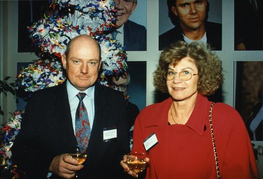 Male and female guest stand in front of a wall of Channel 9 celebrity portraits