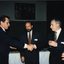 Two men shaking hands past a third man (Ross Johnstone)