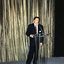 Pete Smith at a podium in front of a gold curtain