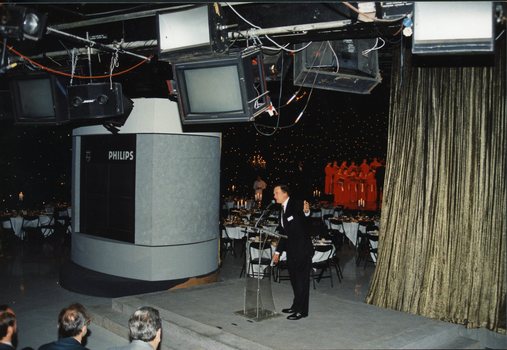 Pete Smith welcomes guests as a gold curtain opens behind him revealing National Boys Choir