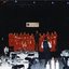 National Boys Choir dressed in red, with their conductor, in front of a starry backdrop with RVIB above them