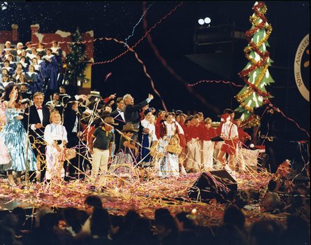 Line of performers on stage surrounded by streamers