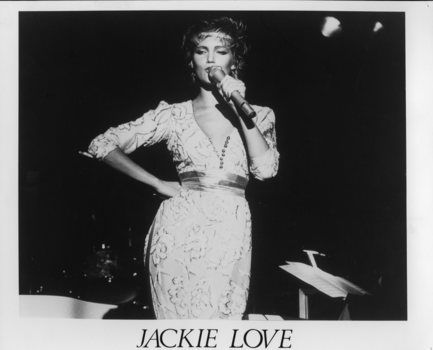 Women singing into microphone with a sassy expression