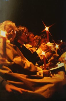 A group of seated adults holding candles