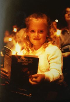 Child in audience holding a program