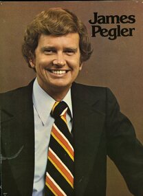 Man in dark suit, light blue shirt and yellow, red and white striped tie