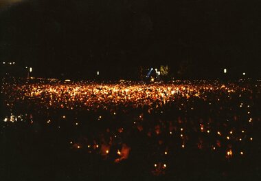 View of the crowd with candles everywhere and a large spotlight centred on the crowd
