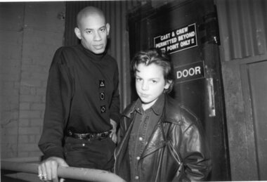 A man and boy stand outside the stage door at the Sidney Myer Music Bowl