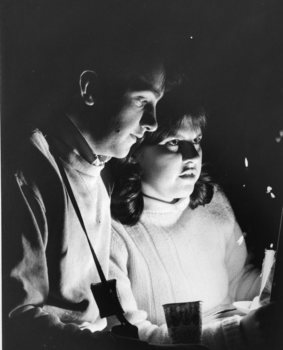 Male and female hold candles at Carols