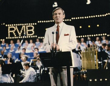 Brian Naylor stands at the podium on stage
