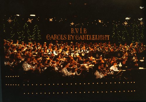 Orchestra on stage with Christmas tree lights in background