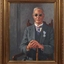 Man wearing dark glasses sits on a chair holding a cane