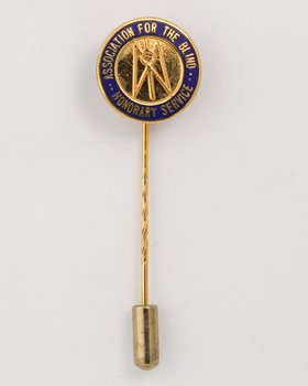Guiding Light symbol on gold background with 'Association for the Blind honorary service' around the edge