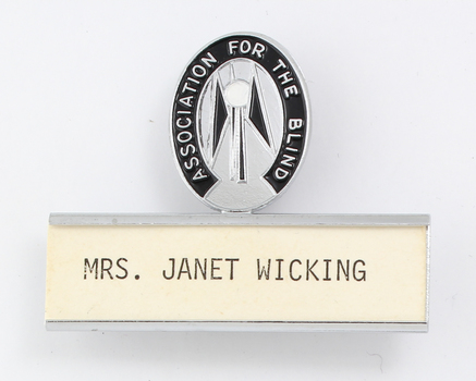 Silver and black guiding light logo with silver name plate underneath and 'Mrs Janet Wicking'