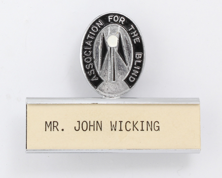 Silver and black guiding light logo with silver name plate underneath and 'Mr John Wicking'