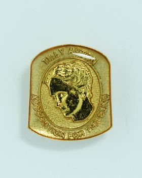 Raised image of woman with bowed head on badge