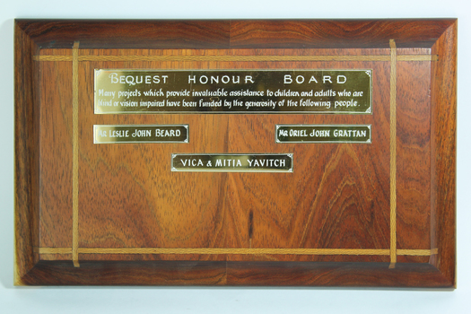 Wooden polished board with gold coloured nameplates 