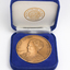 Bronze coloured medallion with illustrations in box