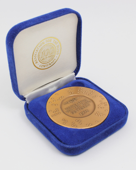 Bronze coloured medallion with illustrations in box