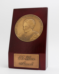 Maroon wooden stand with bronze tone inlaid medallion