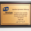 Metal plate mounted on board with blue and black writing
