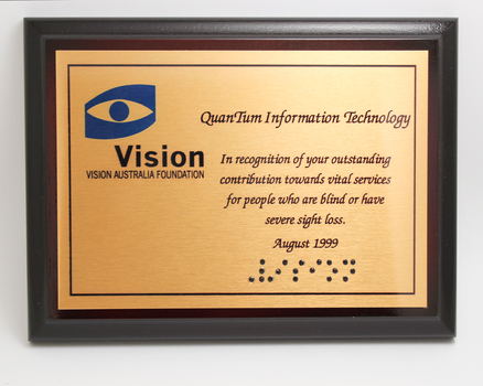 Metal plate mounted on board with blue and black writing