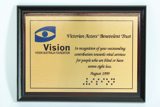 Metal plate mounted on board with blue and black writing