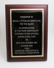Wooden plaque styled like a picture frame with gold writing on black background
