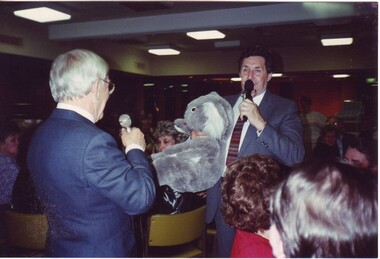 Bob Davis holds a large toy koala as he chats to Lou Richards