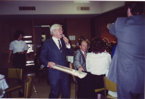 Lou Richards holds a cricket bat