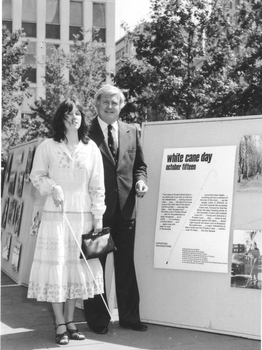 Janene Sadhu with Bill Borthwick next to display boards about White Cane Day