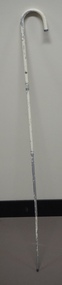 Metal white cane leaning against a wall