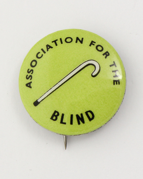 Round badge with white cane on lime green background