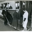 Two people board a bus using their white canes