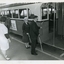 Two people board a bus using their white canes to guide them