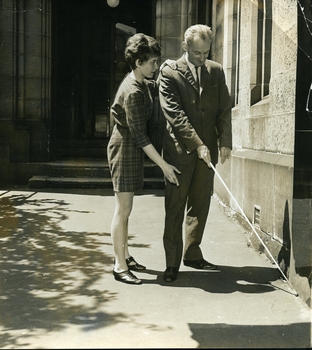 Margaret Rihr assists Michael with his white cane