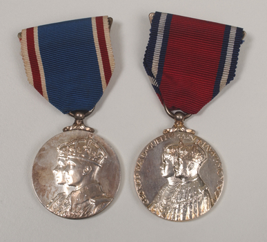 2 silver medals hanging from a red or blue ribbon with blue or red and white edging
