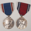 2 silver medals hanging from a red or blue ribbon with blue or red and white edging