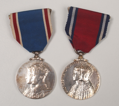 2 silver medals hanging from a red or blue ribbon with blue or red and white edging