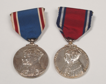 2 silver medals hanging from a red or blue ribbon with blue or red and white edging