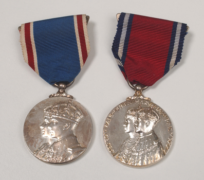 2 silver medals hanging from a red or blue ribbon with blue or red and white edging