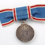 Close up of blue ribbon tied into bow with medal hanging down