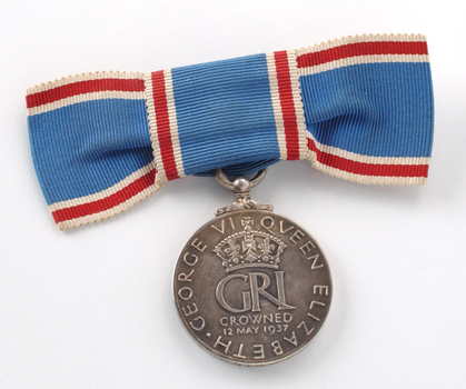 Close up of blue ribbon tied into bow with medal hanging down