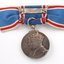 Rear of blue ribbon tied into bow with medal hanging down