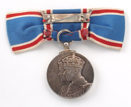Rear of blue ribbon tied into bow with medal hanging down